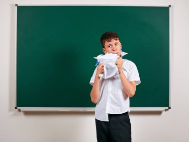 Komik öğrenci portresi. Okul çocuk çok duygusal, eğlenceli ve çok mutlu, kara tahta arka plan sahip - geri okul ve eğitim kavramı