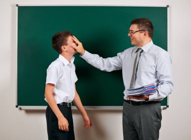 Bir öğretmen ve okul çocuğu kara tahta arka planda oynayan portresi - geri okul ve eğitim kavramı