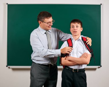 Bir öğretmen ve okul çocuğu kara tahta arka planda oynayan portresi - geri okul ve eğitim kavramı