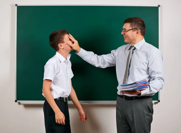 Portret van een leraar en school jongen spelen op Blackboard achtergrond-terug naar school en onderwijsconcept — Stockfoto