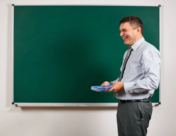 Portrait of a man as a teacher, posing at school board background - learning and education concept — Stock Photo, Image