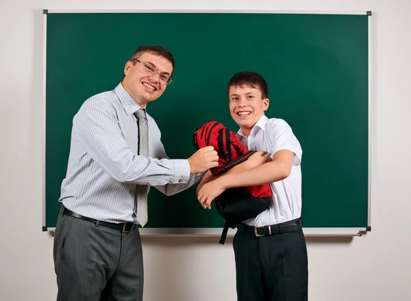 Портрет учителя и школьника, играющего на фоне доски - возвращение к школьной и образовательной концепции — стоковое фото