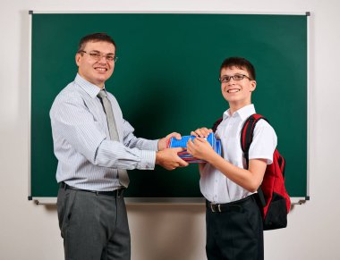 Bir öğretmen ve okul çocuğu kara tahta arka planda oynayan portresi - geri okul ve eğitim kavramı