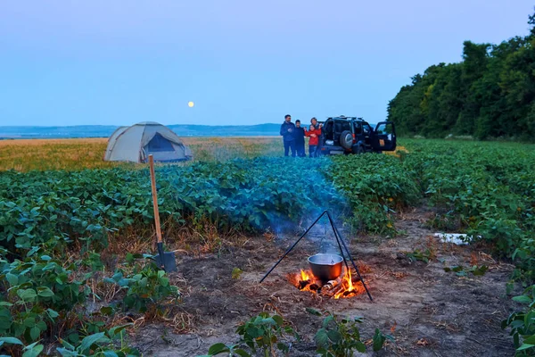 Voyages en famille et camping, crépuscule, cuisine sur le feu. Belle nature - champ, forêt et lune . — Photo