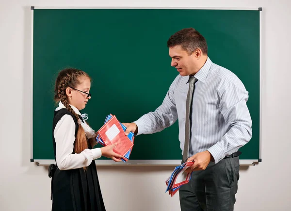 Portret van een leraar en schoolmeisje, poseren op Blackboard achtergrond-terug naar school en onderwijsconcept — Stockfoto