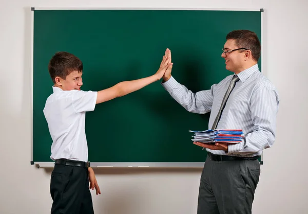 Portret van een leraar en school jongen spelen op Blackboard achtergrond-terug naar school en onderwijsconcept — Stockfoto