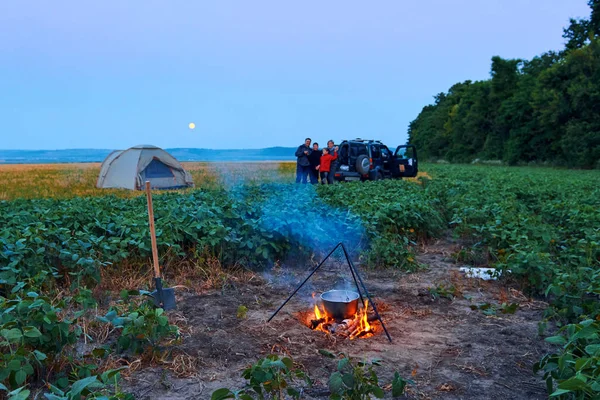 Voyages en famille et camping, crépuscule, cuisine sur le feu. Belle nature - champ, forêt et lune . — Photo