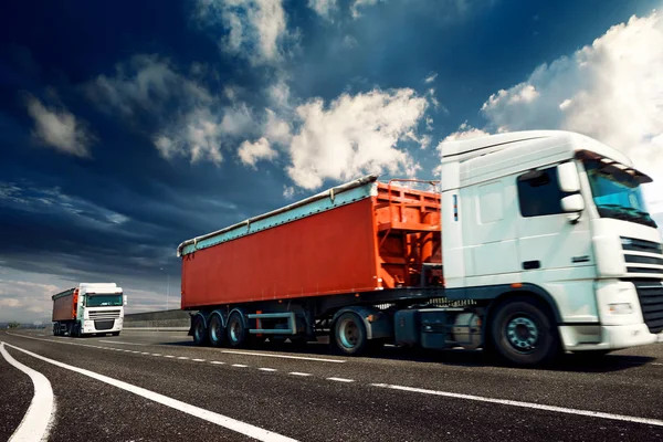Червоні вантажівки знаходяться на шосе бізнес, комерційні, вантажні перевезення концепція, чистий і порожній простір на боці — стокове фото
