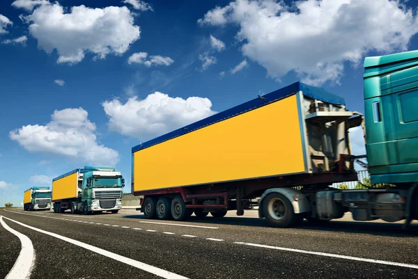 Caminhões amarelos está na estrada - negócio, comercial, conceito de transporte de carga, espaço claro e em branco na vista lateral — Fotografia de Stock
