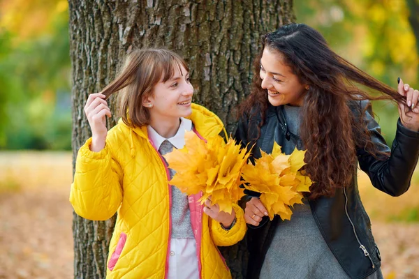 Frau posiert mit Herbstblättern im Stadtpark, Außenporträt — Stockfoto