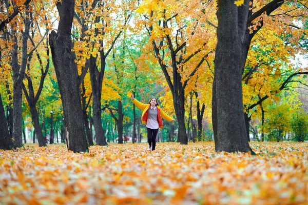 Menina adolescente correndo com folhas de outono no parque da cidade, retrato ao ar livre — Fotografia de Stock