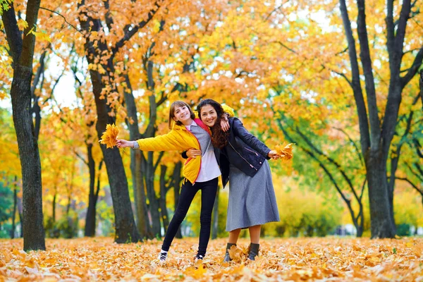 Mulher se divertindo com folhas de outono no parque da cidade, retrato ao ar livre — Fotografia de Stock