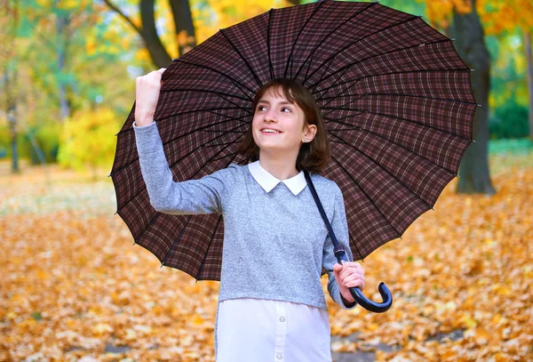 Adolescente posando con paraguas y hojas de otoño en el parque de la ciudad, retrato al aire libre —  Fotos de Stock
