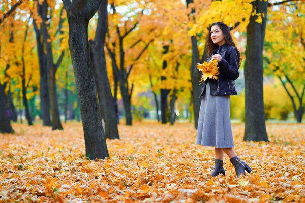 Donna in posa con foglie autunnali nel parco cittadino, ritratto all'aperto — Foto Stock