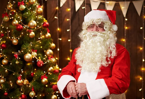 Portrait du Père Noël, assis à l'intérieur près décoré arbre de Noël avec des lumières Joyeux Noël et Joyeuses Fêtes! — Photo