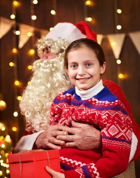 Санта Клаус і маленька дівчинка, що зібралися в приміщенні біля прикрашеного ксам дерева зі світлом, розмовляють і посміхаються - Веселого Різдва і Веселих свят.! — стокове фото