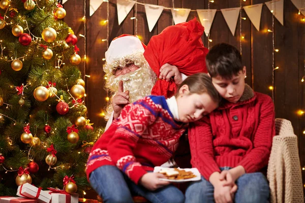 Діти довго чекали на Санту, тепер вони заснули і Санта спокійно йде на різдвяне дерево, щоб подарувати подарунки - Веселих свят і Веселих свят.! — стокове фото