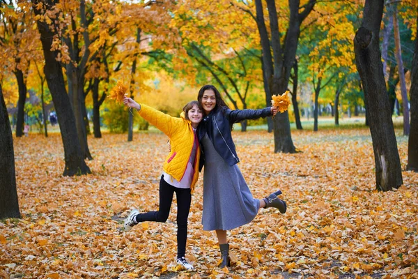 Mujer divirtiéndose con hojas de otoño en el parque de la ciudad, retrato al aire libre — Foto de Stock