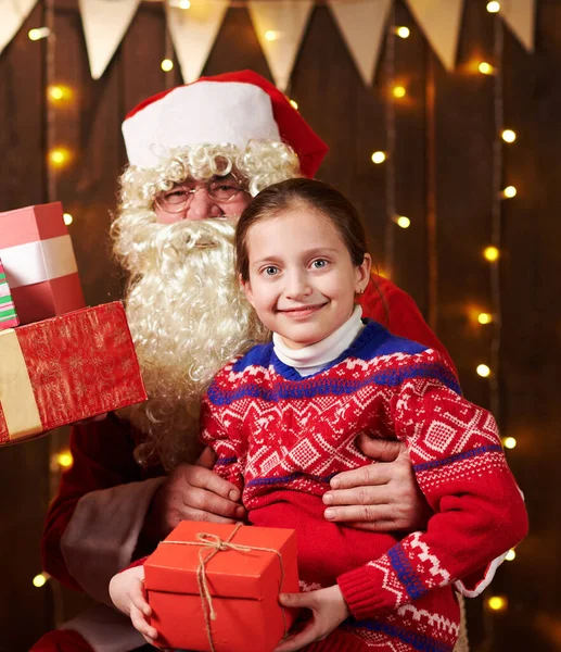 Санта Клаус і маленька дівчинка, що зібралися в приміщенні біля прикрашеного ксам дерева зі світлом, розмовляють і посміхаються - Веселого Різдва і Веселих свят.! — стокове фото