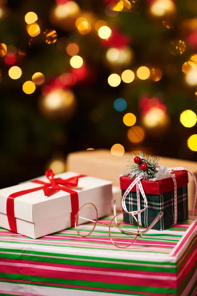 Close-up of gift boxes. Christmas lights and decoration on dark background - Happy Holidays concept — Stock Photo, Image