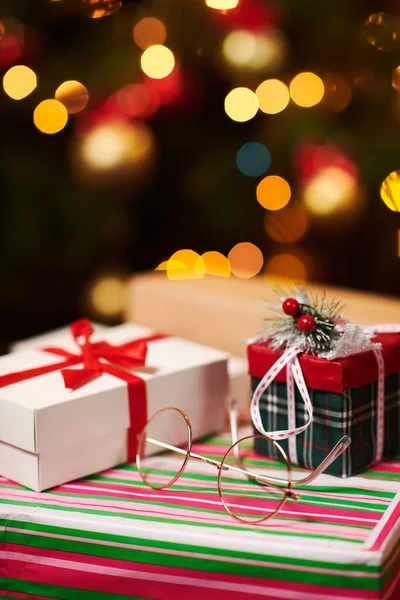 Close-up of gift boxes. Christmas lights and decoration on dark background - Happy Holidays concept — Stock Photo, Image