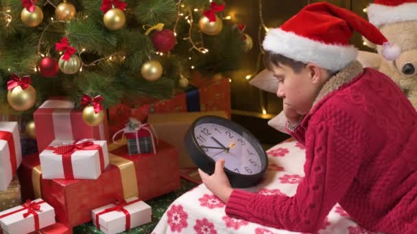 Teen Boy Waiting Santa Watching Clock Που Βρίσκεται Εσωτερικούς Χώρους — Αρχείο Βίντεο