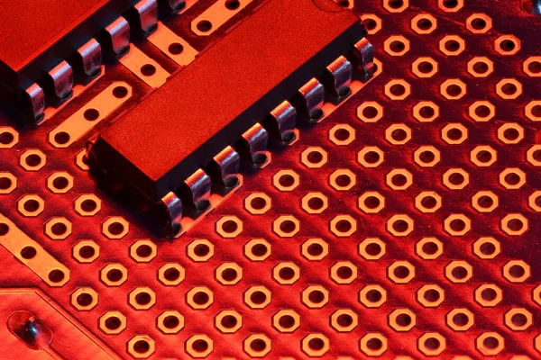 Placa de circuito impresso e microchip em close-up luz vermelha - componente eletrônico para equipamentos digitais, conceito para o desenvolvimento de circuitos de computador elétrico — Fotografia de Stock