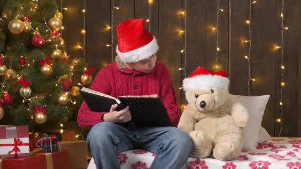 Santa Helper Jongen Lezen Boek Speelgoed Dragen Zittend Binnen Buurt — Stockvideo