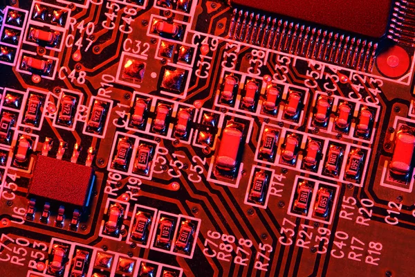 Printplaat en microchip, of cpu, in rood licht close-up - elektronische component voor digitale apparatuur, concept voor de ontwikkeling van elektrische computercircuits — Stockfoto