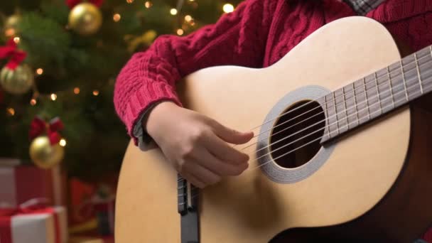 Adolescente Che Suona Chitarra Seduto Coperto Vicino All Albero Natale — Video Stock