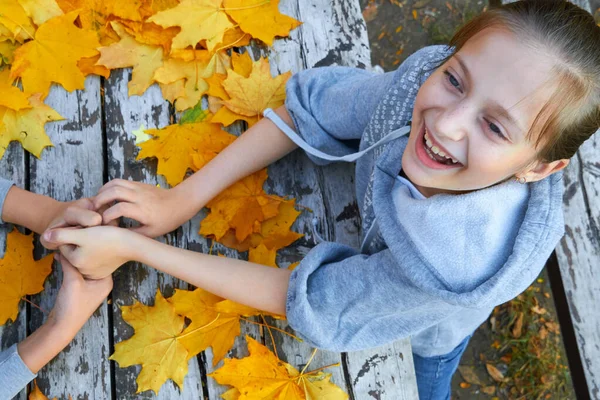 Ragazza con autunno foglie su sfondo di legno — Foto Stock