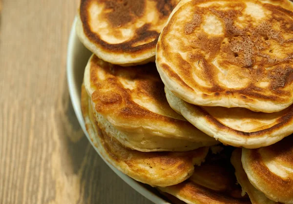 Stack of delicious homemade pancakes on plate, wooden table as background — Stock Photo, Image