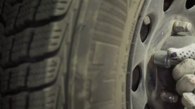 Bir araba tekerleğini değiştirmek, bir garajda vida sökmek ve vidaları vidalamak.