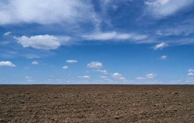 Pürüzsüz tarlalar, toprak ve bulutlar parlak güneşli bir günün - tarım kavramı