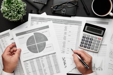 Finansal raporlarla çalışan işadamlarının üst düzey görüşü. Defteri, kalemi ve bir sürü şeyi olan modern siyah ofis masası. Düz masa düzeni.
