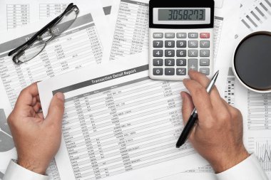 Finansal beyannamelerle çalışan iş adamlarının üst görüşü. Defteri, kalemi ve bir sürü şeyi olan modern siyah ofis masası. Düz masa düzeni.