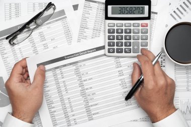 Finansal beyannamelerle çalışan iş adamlarının üst görüşü. Defteri, kalemi ve bir sürü şeyi olan modern siyah ofis masası. Düz masa düzeni.