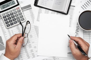 Finansal beyannamelerle çalışan iş adamlarının üst görüşü. Defteri, kalemi ve bir sürü şeyi olan modern siyah ofis masası. Düz masa düzeni.