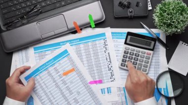 Finansal beyannamelerle çalışan iş adamlarının üst görüşü. Defteri, kalemi ve bir sürü şeyi olan modern siyah ofis masası. Düz masa düzeni.