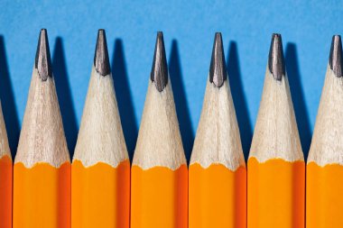 Mavi arka plan makro fotoğraf, okul ve ofis malzemeleri üzerinde grafit kalemler.