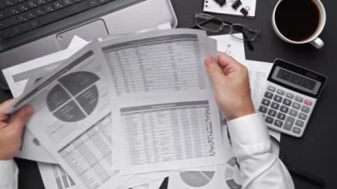 Finansal beyannamelerle çalışan iş adamlarının üst görüşü. Defteri, kalemi ve bir sürü şeyi olan modern siyah ofis masası. Düz masa düzeni.