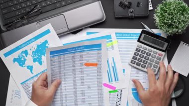 Finansal beyannamelerle çalışan iş adamlarının üst görüşü. Defteri, kalemi ve bir sürü şeyi olan modern siyah ofis masası. Düz masa düzeni.