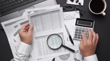 Finansal beyannamelerle çalışan iş adamlarının üst görüşü. Defteri, kalemi ve bir sürü şeyi olan modern siyah ofis masası. Düz masa düzeni.