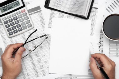 Finansal beyannamelerle çalışan iş adamlarının üst görüşü. Defteri, kalemi ve bir sürü şeyi olan modern siyah ofis masası. Düz masa düzeni.