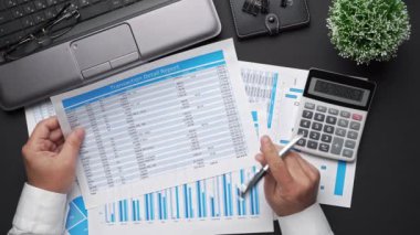 Finansal beyannamelerle çalışan iş adamlarının üst görüşü. Defteri, kalemi ve bir sürü şeyi olan modern siyah ofis masası. Düz masa düzeni.