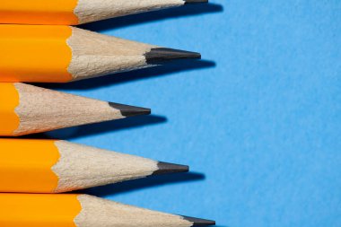 Mavi arka plan makro fotoğraf, okul ve ofis malzemeleri üzerinde grafit kalemler.
