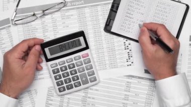 Finansal beyannamelerle çalışan iş adamlarının üst görüşü. Defteri, kalemi ve bir sürü şeyi olan modern siyah ofis masası. Düz masa düzeni.
