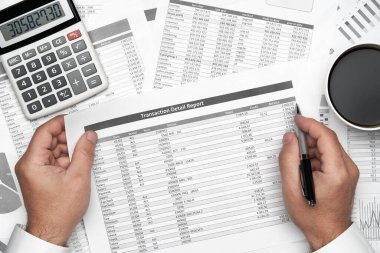 Finansal beyannamelerle çalışan iş adamlarının üst görüşü. Defteri, kalemi ve bir sürü şeyi olan modern siyah ofis masası. Düz masa düzeni.