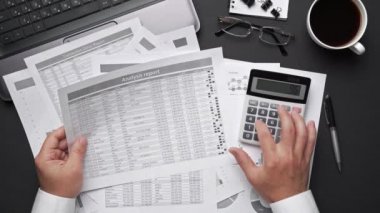 Finansal beyannamelerle çalışan iş adamlarının üst görüşü. Defteri, kalemi ve bir sürü şeyi olan modern siyah ofis masası. Düz masa düzeni.