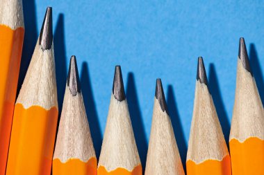 Mavi arka plan makro fotoğraf, okul ve ofis malzemeleri üzerinde grafit kalemler.